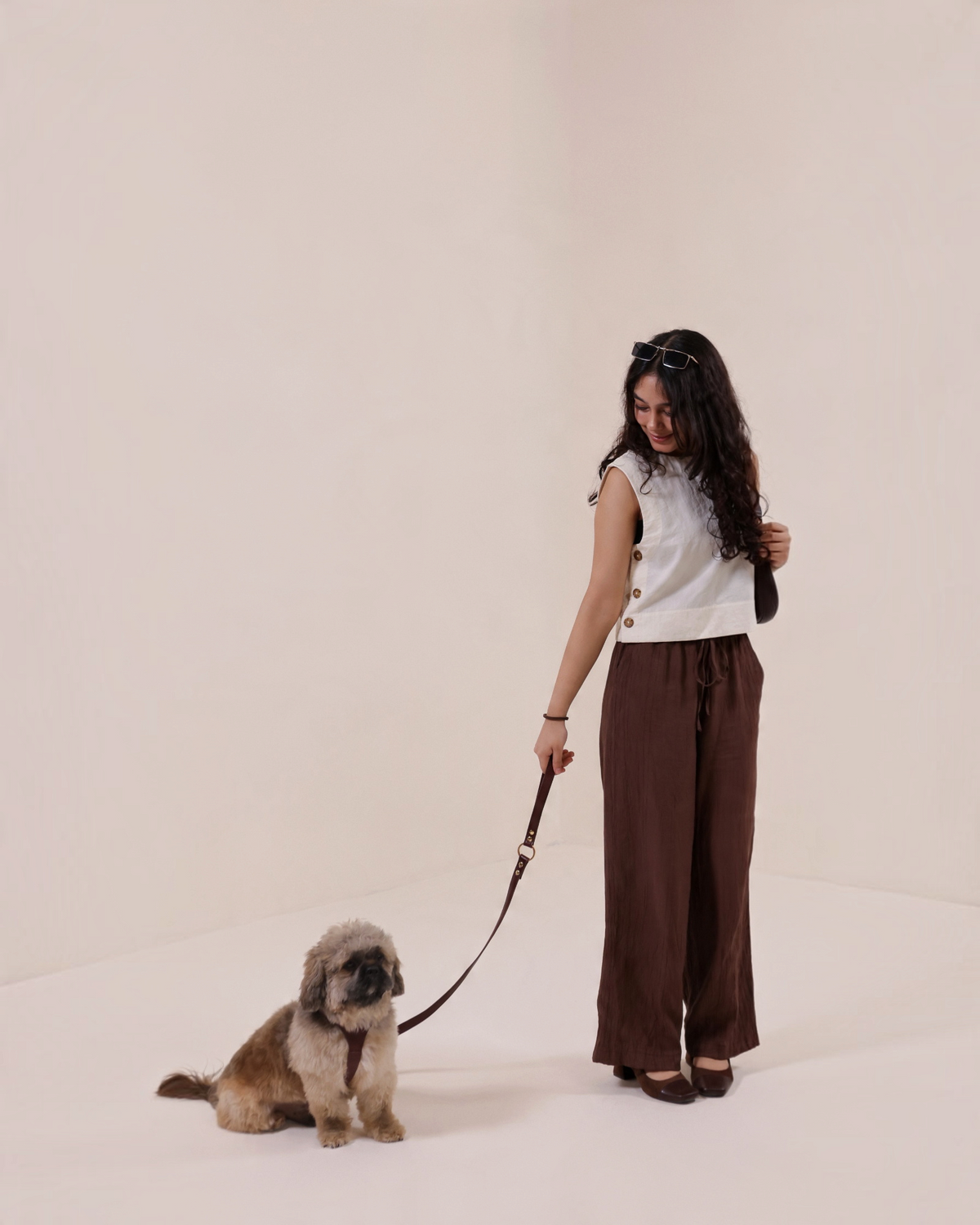 The bond vegetable tanned brown leather dog lead held by a woman walking a small dog in a studio setting